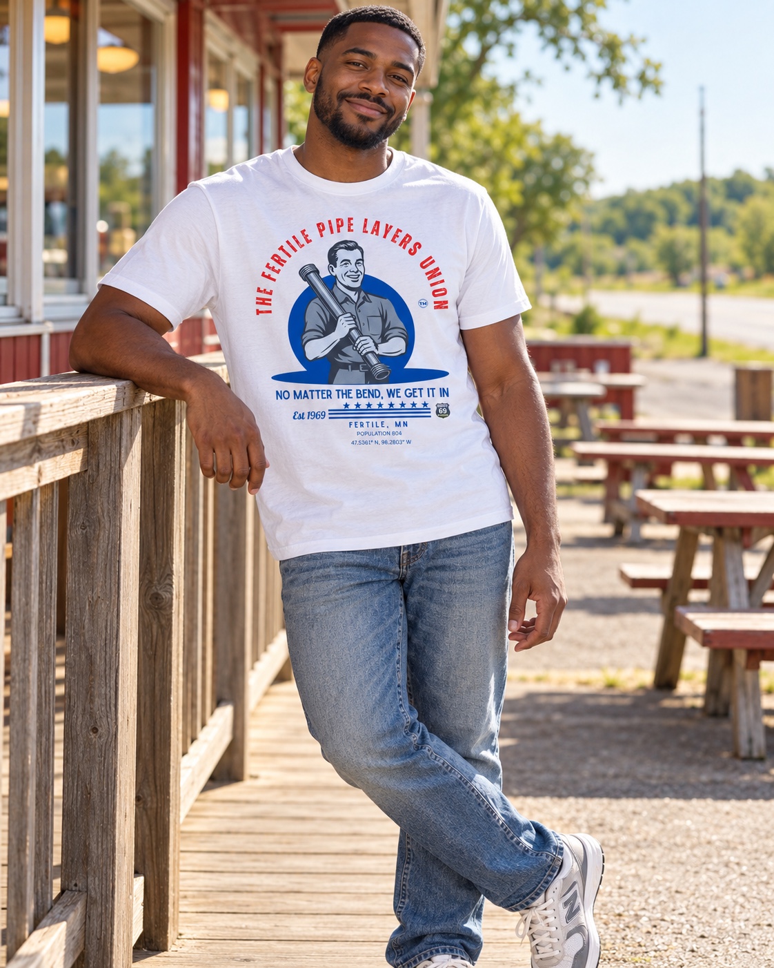 Model wearing the white Fertile Pipe Layers Union tee on a roadside porch